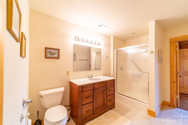 bathroom with oversized vanity, toilet, tile floors, and a shower with shower door