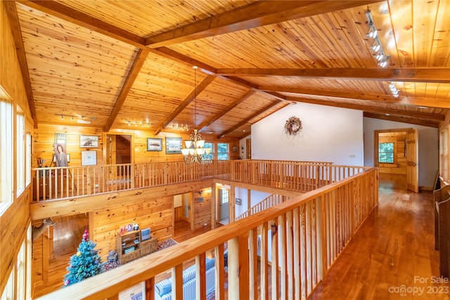 hall featuring plenty of natural light, an inviting chandelier, and vaulted ceiling with beams