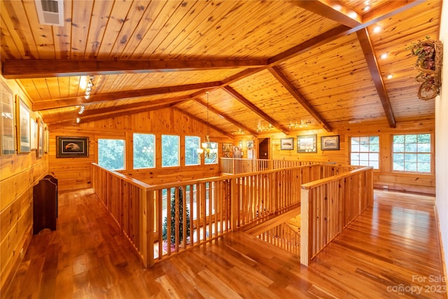 hall with wooden ceiling, vaulted ceiling with beams, and a wealth of natural light