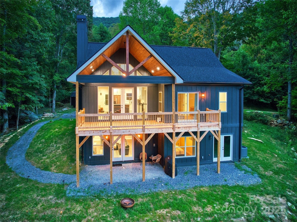 rear view of house with a lawn, a deck, and central air condition unit