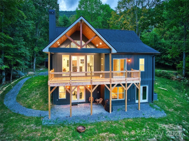 rear view of house with a lawn, a deck, and central air condition unit