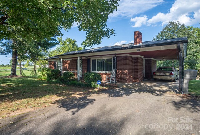 view of front facade featuring a front yard and a carport