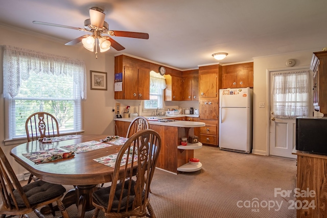 carpeted dining area featuring sink and ceiling fan