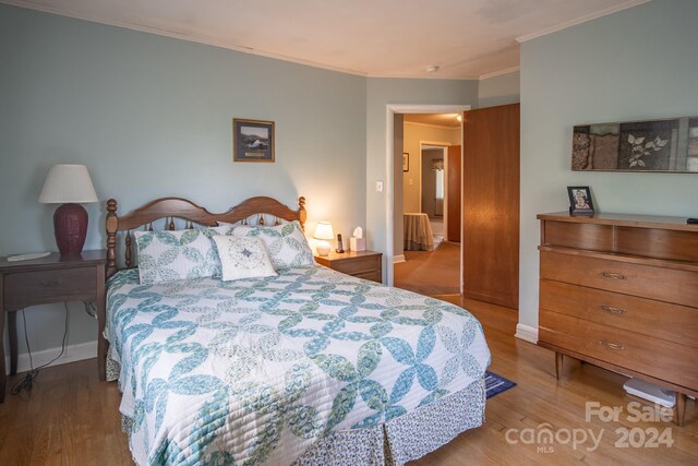 bedroom featuring light hardwood / wood-style flooring and crown molding