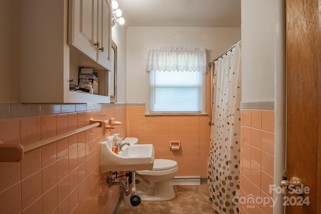 bathroom featuring sink, tile flooring, toilet, and tile walls