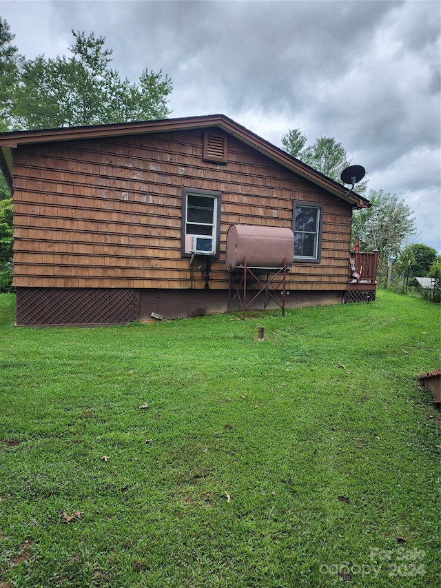 view of side of home featuring a wooden deck and a lawn