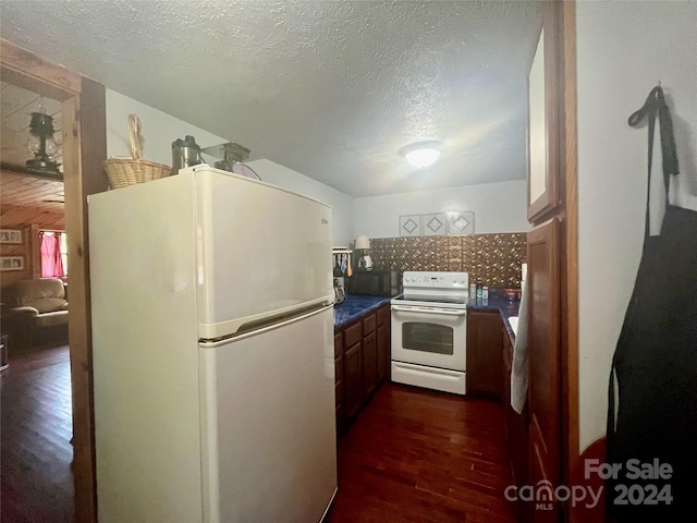 kitchen featuring dark hardwood / wood-style floors, white appliances, and a textured ceiling