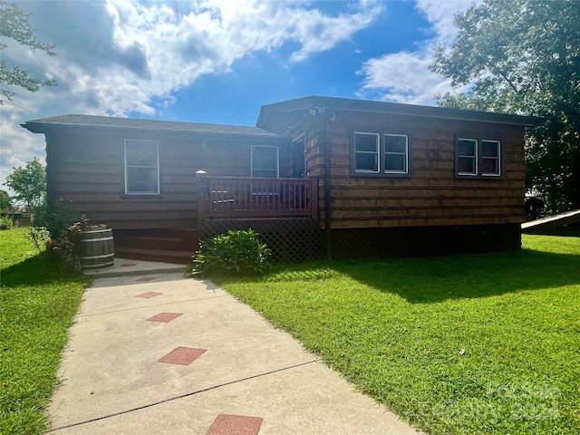 view of front of house with a deck, a front yard, and central AC