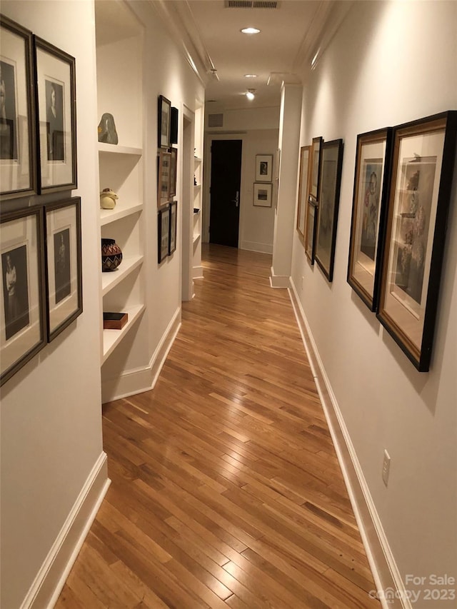 corridor featuring built in shelves and dark wood-type flooring