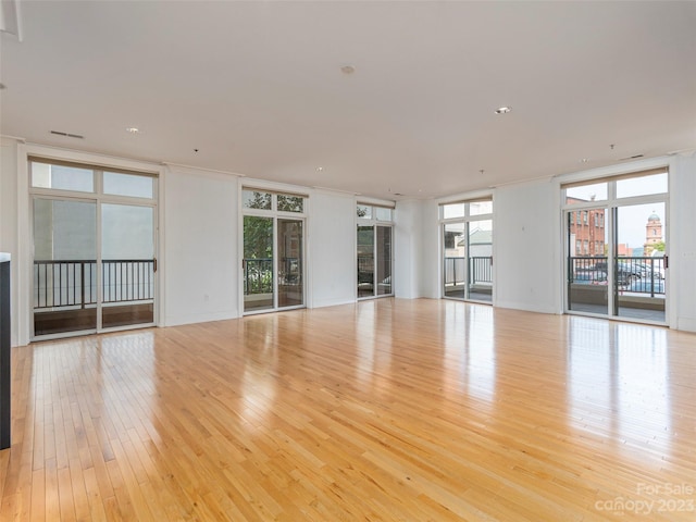 unfurnished living room featuring light hardwood / wood-style flooring and floor to ceiling windows