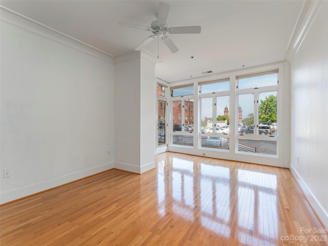 spare room featuring ornamental molding, ceiling fan, and light wood-type flooring