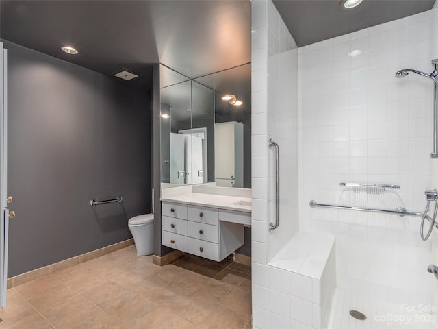 bathroom featuring vanity, toilet, tiled shower, and tile floors