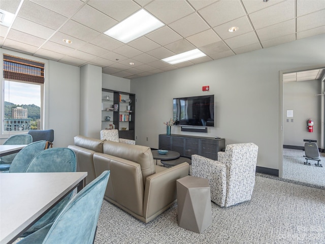 carpeted living room featuring a paneled ceiling