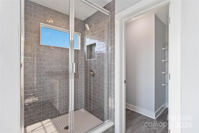 bathroom with wood-type flooring and walk in shower