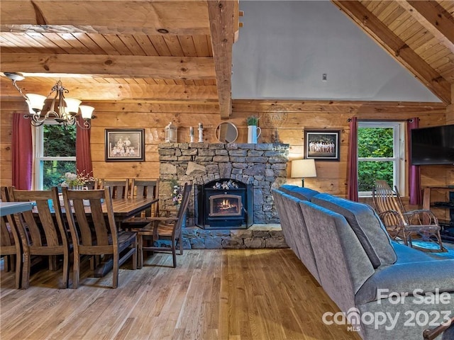 unfurnished dining area with hardwood / wood-style floors, wooden walls, a fireplace, a chandelier, and wooden ceiling