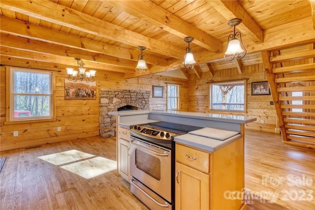 kitchen featuring a notable chandelier, wood walls, decorative light fixtures, and light hardwood / wood-style floors