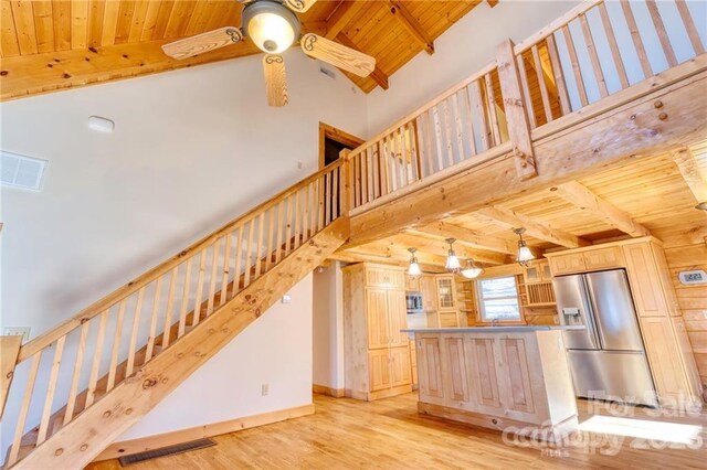 interior space with wooden ceiling, high vaulted ceiling, light wood-type flooring, ceiling fan, and beam ceiling