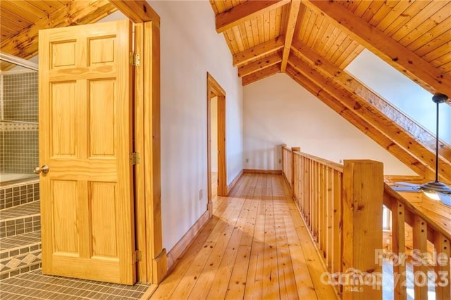 corridor featuring wooden ceiling, vaulted ceiling with skylight, and light hardwood / wood-style flooring