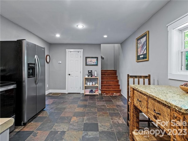 kitchen with stainless steel refrigerator with ice dispenser, dark tile floors, and range