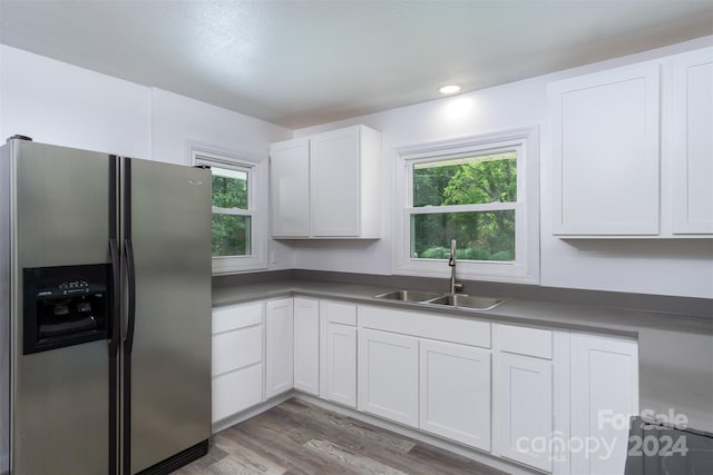 kitchen with white cabinetry, sink, stainless steel fridge with ice dispenser, and hardwood / wood-style floors