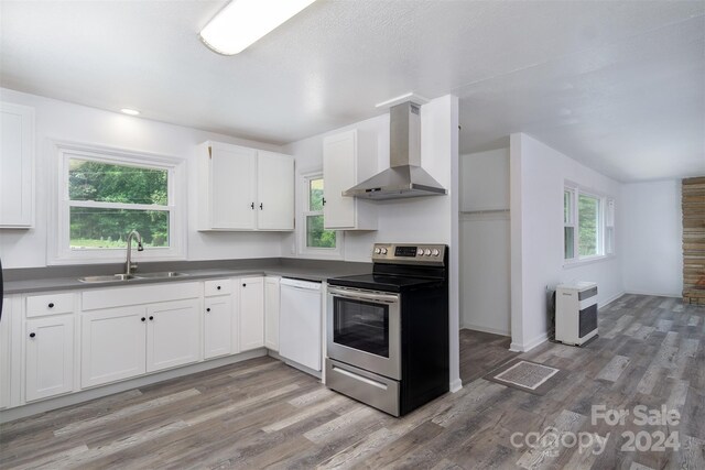 kitchen featuring sink, white cabinetry, electric range, dishwasher, and wall chimney range hood