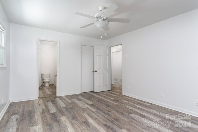 unfurnished bedroom featuring light hardwood / wood-style floors, ceiling fan, and ensuite bathroom