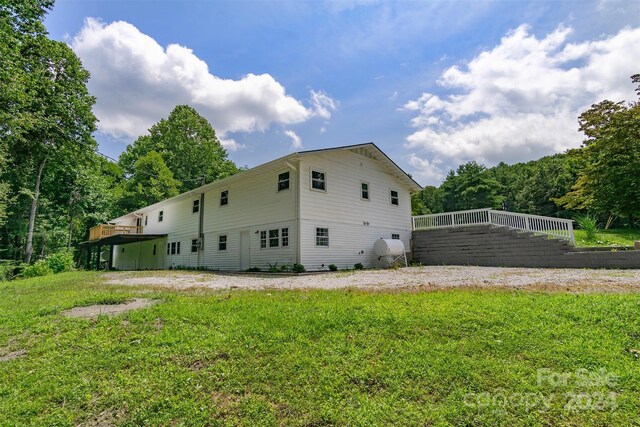 view of side of home with a yard