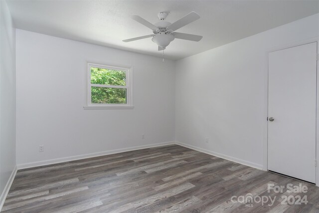 empty room with dark hardwood / wood-style floors and ceiling fan