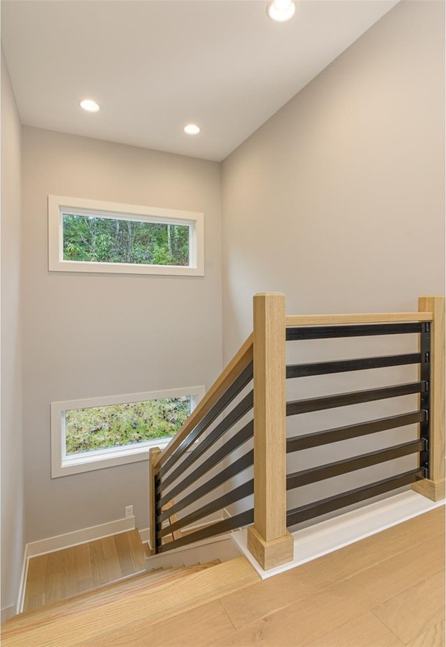 stairway with hardwood / wood-style floors and a wealth of natural light