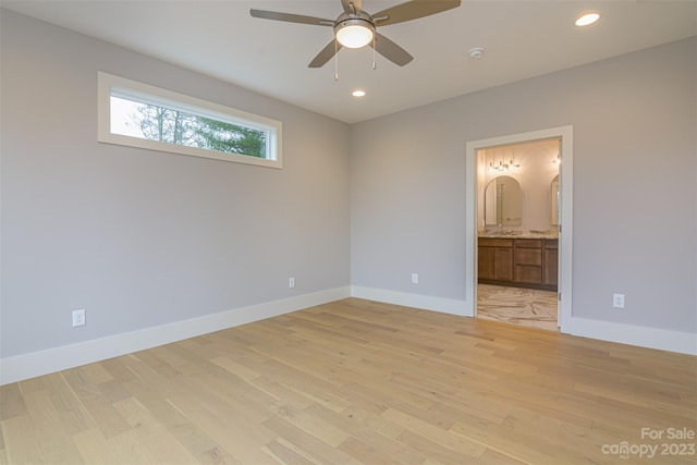 unfurnished bedroom featuring ceiling fan, light wood-type flooring, and ensuite bath