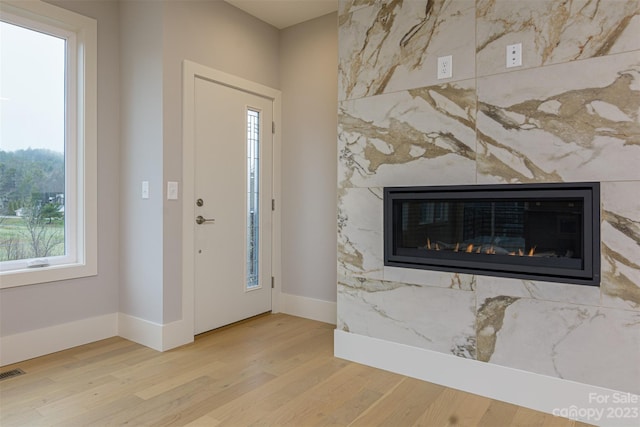 entrance foyer featuring wood-type flooring and a fireplace