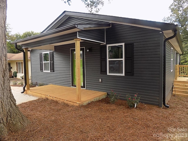 rear view of house featuring a wooden deck