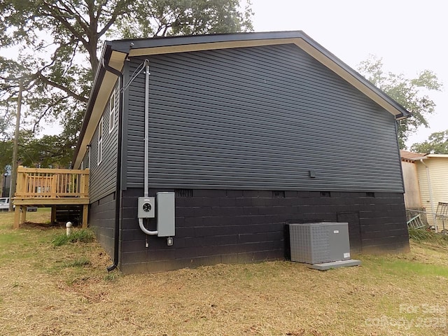 view of home's exterior featuring a wooden deck, central AC unit, and a yard