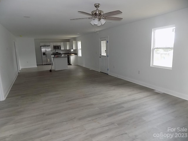 unfurnished living room with ceiling fan and light hardwood / wood-style floors