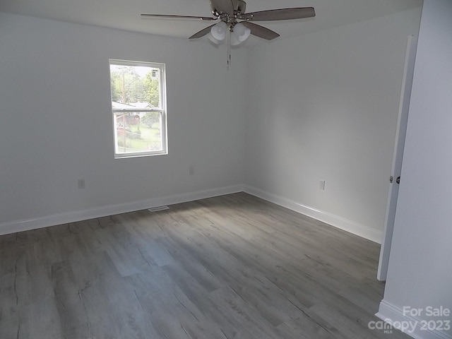 empty room featuring ceiling fan and dark wood-type flooring