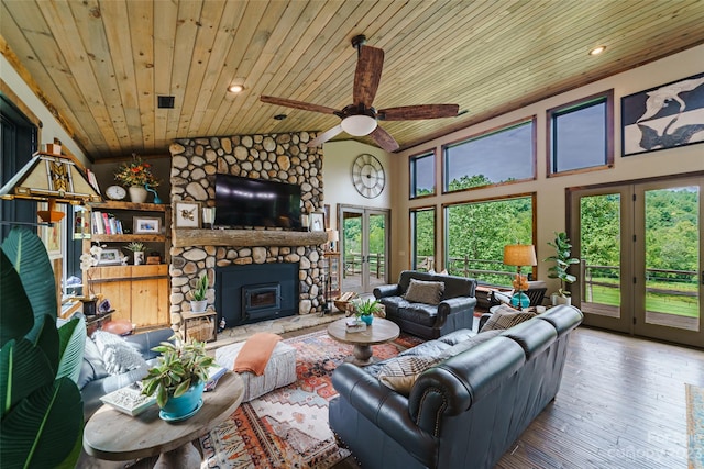 living room with lofted ceiling, ceiling fan, wood-type flooring, wooden ceiling, and a stone fireplace