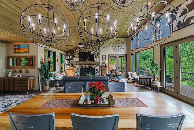 living room featuring plenty of natural light, a stone fireplace, and wood ceiling