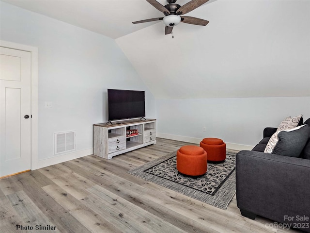 living room with lofted ceiling, ceiling fan, and light wood-type flooring