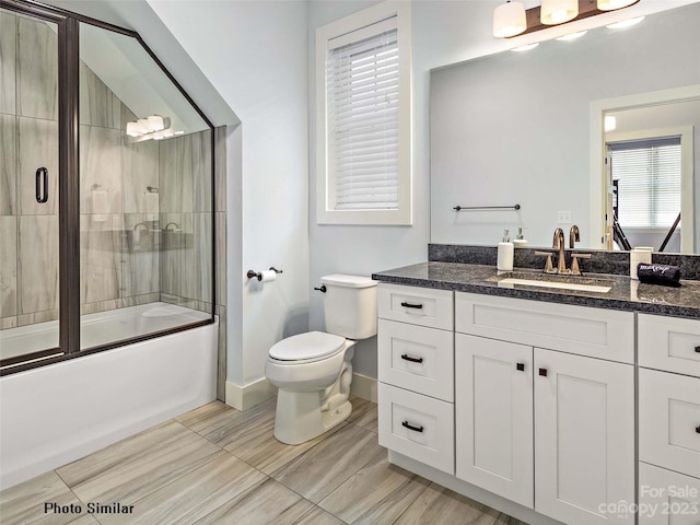 full bathroom featuring tile floors, toilet, bath / shower combo with glass door, and vanity