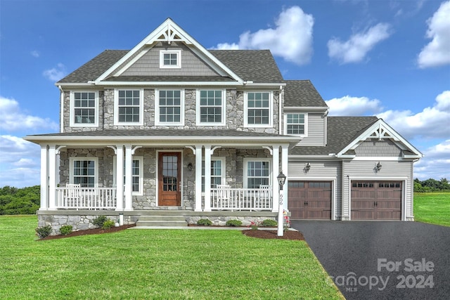 view of front of property with a front lawn, covered porch, and a garage