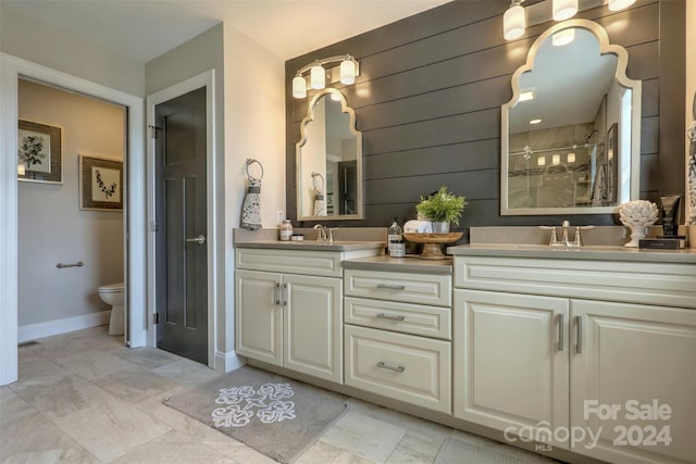 bathroom featuring vanity, wood walls, toilet, and walk in shower