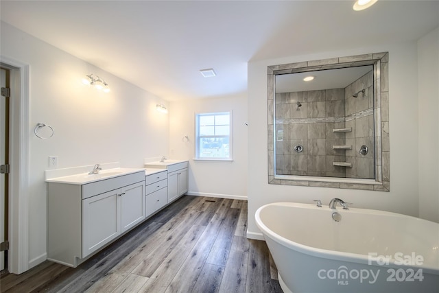 bathroom with hardwood / wood-style floors, vanity, and separate shower and tub