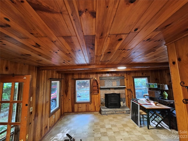 interior space with wood ceiling, a fireplace, wood walls, and light tile floors