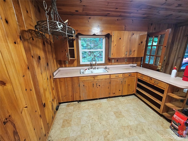 kitchen featuring wooden ceiling, wooden walls, sink, and light tile floors