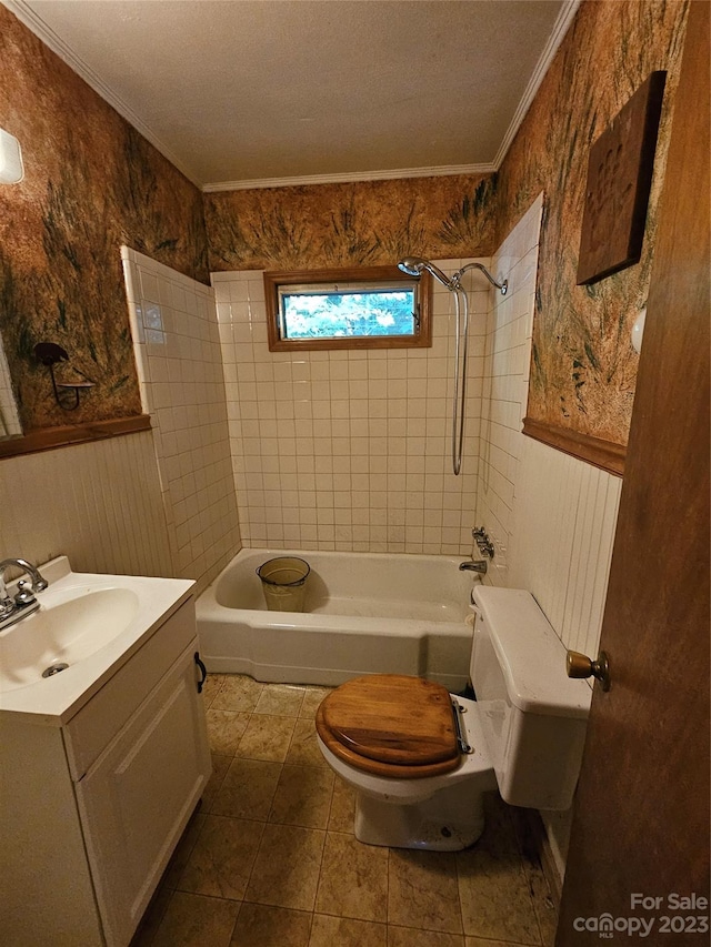 full bathroom featuring a textured ceiling, toilet, tiled shower / bath, and vanity with extensive cabinet space