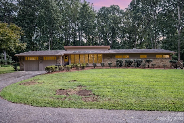 view of front facade featuring a lawn and a garage