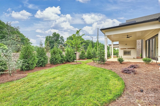 view of yard featuring a patio, an outdoor brick fireplace, and ceiling fan