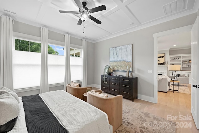 bedroom featuring a fireplace, ceiling fan, light hardwood / wood-style floors, coffered ceiling, and crown molding