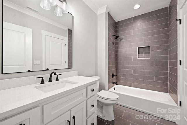 full bathroom with tiled shower / bath combo, toilet, crown molding, vanity, and tile patterned floors