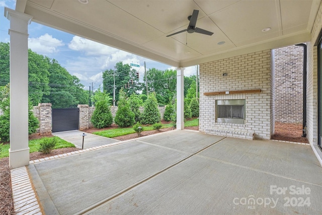 view of patio featuring an outdoor brick fireplace and ceiling fan